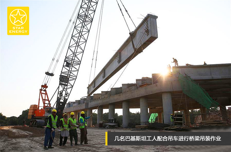 幾名巴基斯坦工人配合吊車進行橋梁吊裝作業(yè)